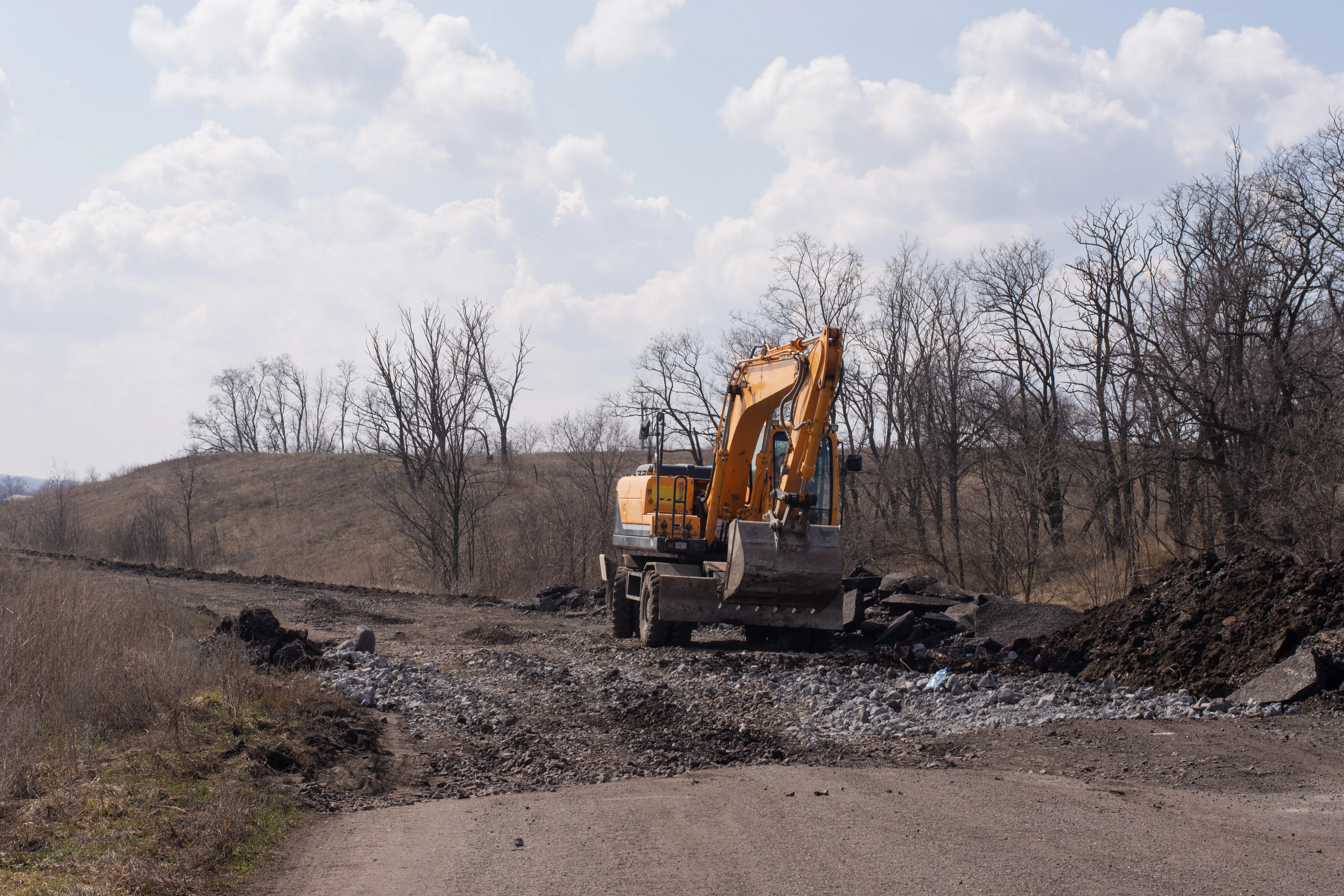 Gravel road construction and grading services in Placer County - professional excavator performing road work in Auburn California